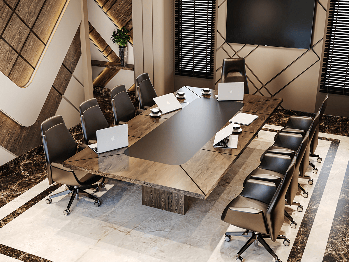 A long, wooden conference table with a black top sits in a well-lit meeting room. Several black leather chairs with wheels are positioned around the table. Laptops are scattered on the table surface. In the background, a large window offers a view of a cityscape.